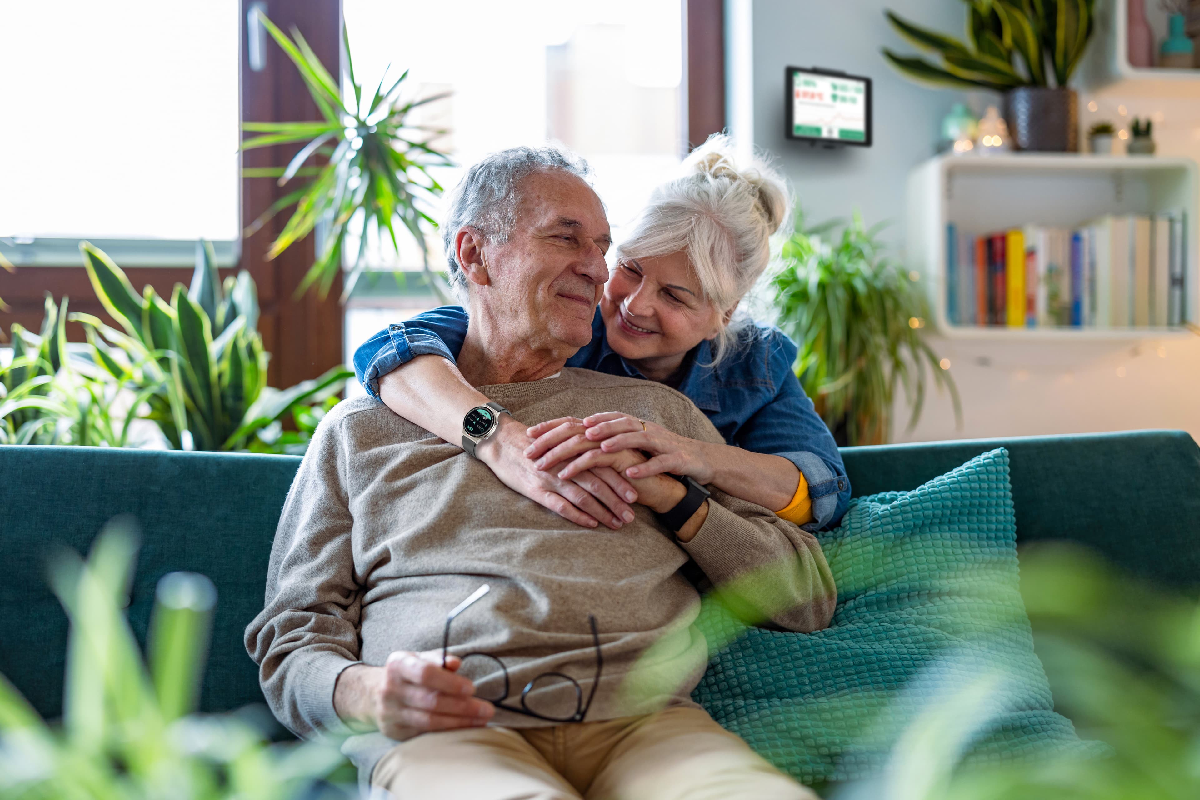 Elderly couple in the living room, feeling safe and secure, wearing a ViveHome watch