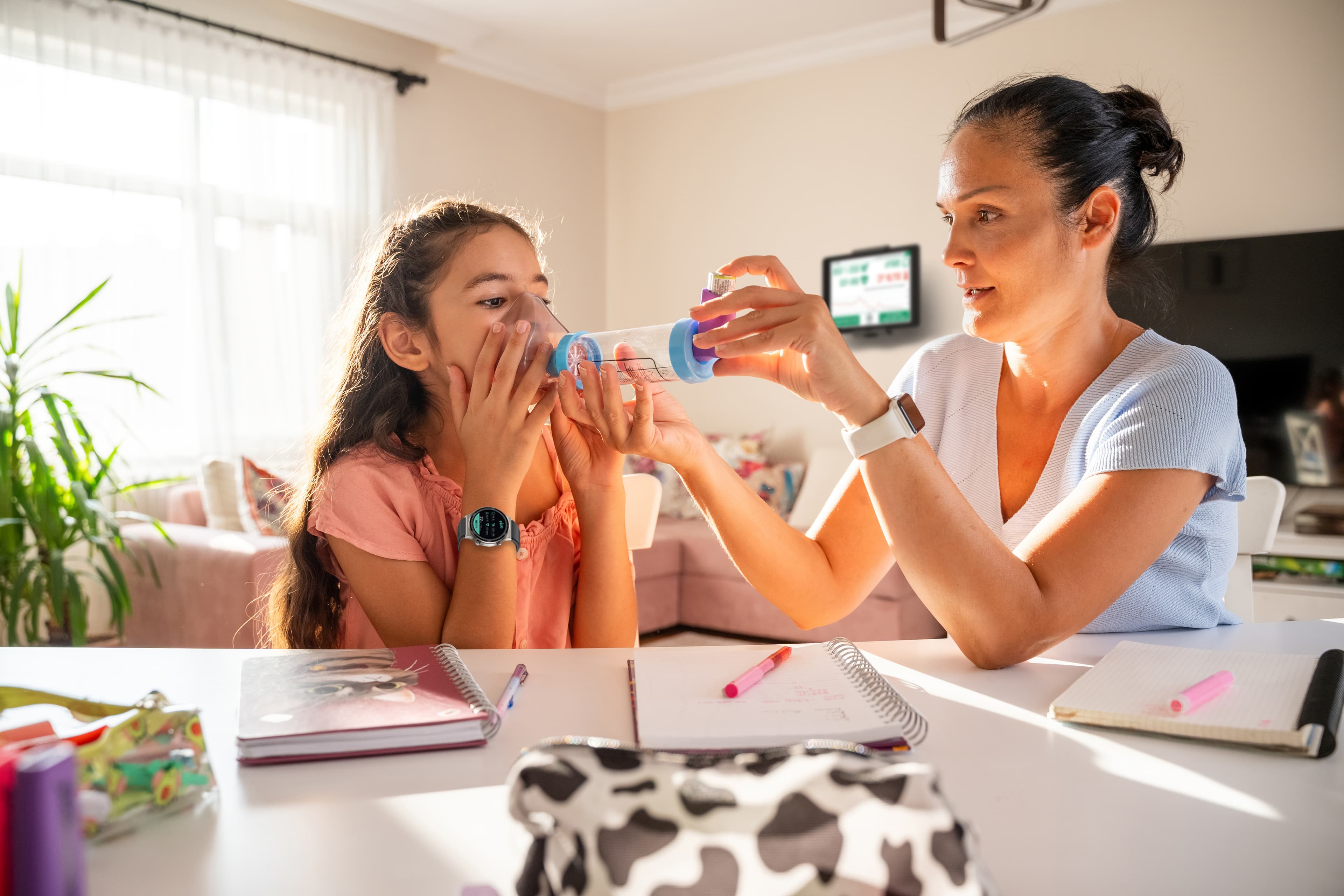 Mother administers medication to her daughter, wearing a ViveHome watch